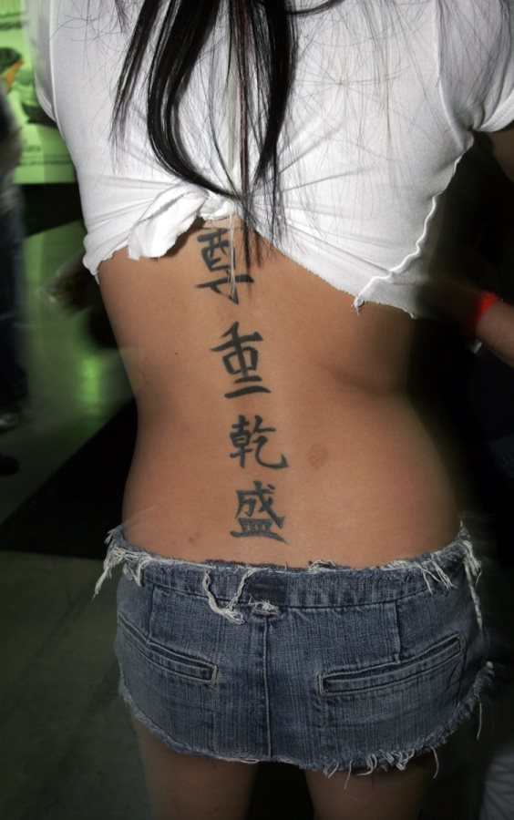 Esta chica muestra este tatuaje de un conjunto de smbolos chinos tatuados verticalmente a lo largo del centro de la espalda, llegando hasta la parte lumbar de sta