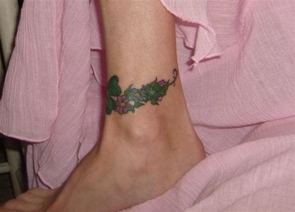 Ramillete de flores en las que predomina el color verde hacen de este pequeño tatuje un gran tattoo que rodea todo el tobillo y que combinarán perfectamente con cualquier ropa o adorno que lleves porque son colores muy natuales que resaltan la piel de cualquier persona y que quedan geniales a cualquier persona