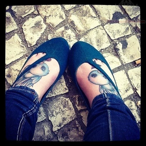 Tatuajes gemelos sobre los pies d eunas simpáticas golondrinas a la que se le han dibujado pequeños detalles alrededor de los pájaros