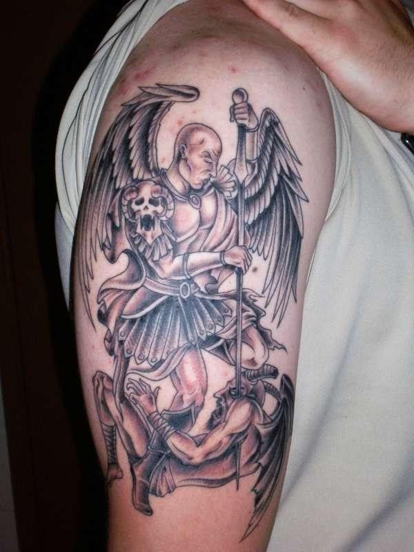 Tatuaje de un ángel guerrero en el brazo que se encuentra matando a un demonio, como se puede apreciar, el tatuaje cuenta con una gran variedad de detalles, desde unas muy bien conseguidas alas plumadas, a una armadura muy bien hecha y unas sombras, tanto del guerrero como del demonio, muy bien terminadas