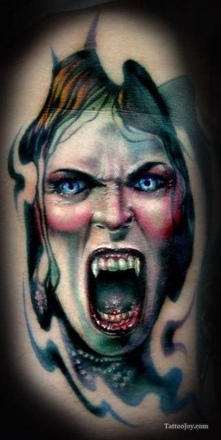 Tatuaje de la cara de una mujer vampiro en el que se destacan los grandes colmillos, los buenos brillos conseguidos en la cara, pero sobre todo nos gustaría resaltar el buen acabado de los pómulos de la cara, para el que se ha conseguido un buen color y unas sombras perfectas