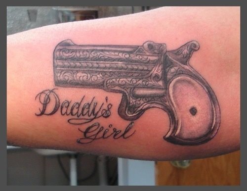 Tatuaje de un revolver gravado de que destacamos la gran anchura del cañón, a pesar de ser corto y que junto al tatto se han tatuado las palabras Daddy´s girl, un tatuaje muy mafioso y que nos recuerda a algunas canciones de reggaeton, por lo que si tienes una idea parecida pero no quieres que se parezca a este tipo de música, ya sabes lo que no debes hacer