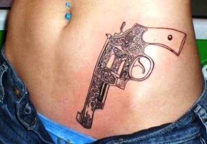 Revolver tatuado sobre la zona típica y clásica de tatuar pistolas, ya que emula al sitio donde los malos de las películas llevan las pistolas