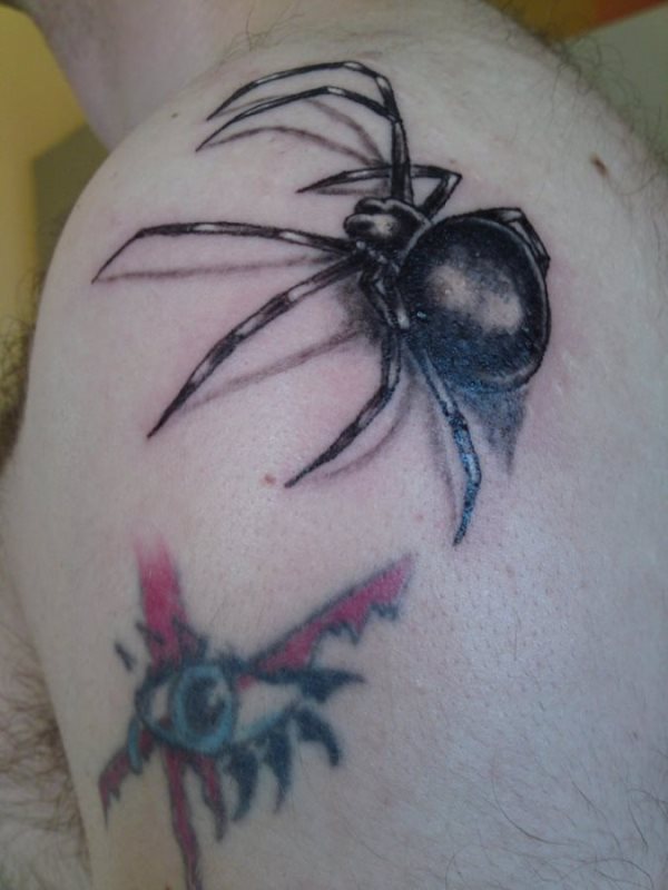 Tatuaje de una araña que parece trepar por la espalda de este chico, en esta ocasión se han diseñado unas patas bastante largas y unas sombras poco definidas, tal vez con algunos toques de color amarillo a la araña, le daría un aire fabuloso