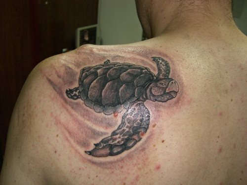 Tattoo en la parte superior de la espalda de una tortuga marina nadando