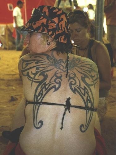 Tatuaje tribal de dos alas con la forma de las alas de una mariposa, este tattoo ocupa un gran tamaño en la espalda de esta chica que como podemos observar luce con gran orgullo su gran tattoo y no es para menos, porque le ha quedado un diseño fantástico