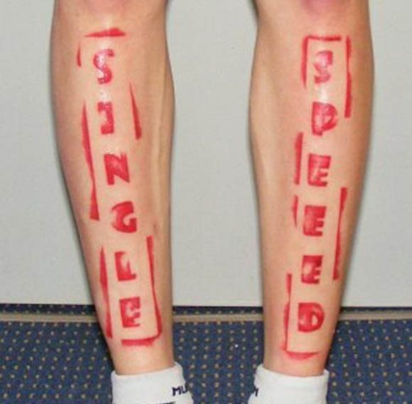 Tatuaje en la pierna que tiene un estilo como si de un sello de tinta se tratase, en una pierna se aprecia la palabra single y en la otra pierna la palabra speed, sendos tatuajes han sido tatuados sobre la parte delantera de las piernas