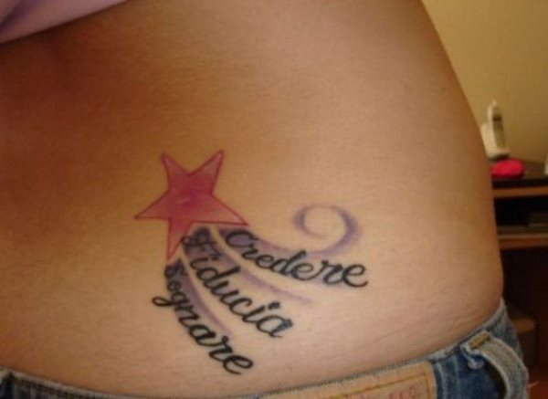 Tatuaje en la cintura de uan estrella roja de cinco puntas, de la que salen tres destellos de color morado y sobre ellos se han tatuado una palabra en cada uno de los destellos, un tattoo sencillo, sin complicaciones y que ha dado un buen resultado