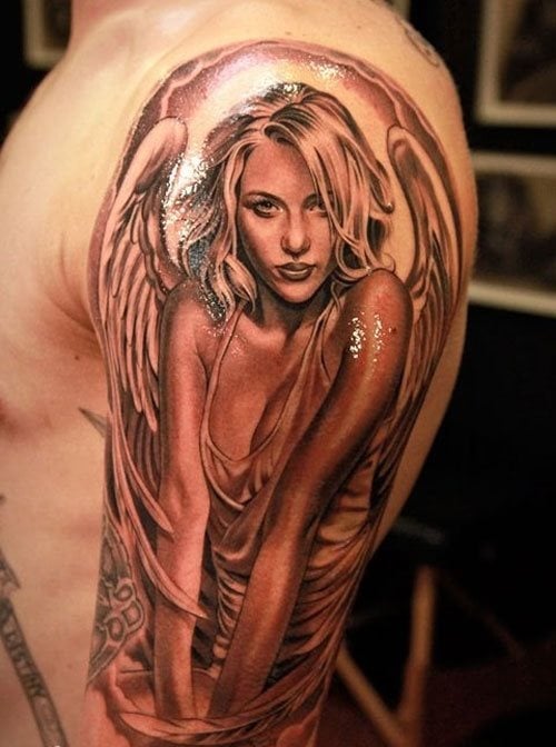 Tatuaje de una bella mujer con una camiseta escotada y una cara súper bonita, a la que se le han añadido dos grandes alas plumadas