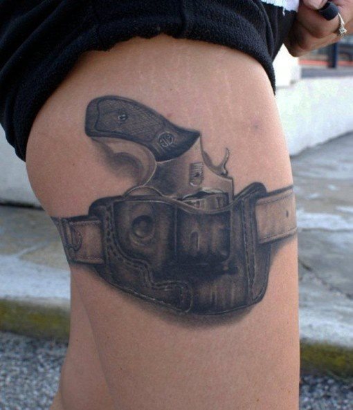 En lugar de un liguero, como hemos visto en otras imgenes anteriores, la pistola tatuada sobre la pierna est sujeta por su propia funda, tambin tatuada