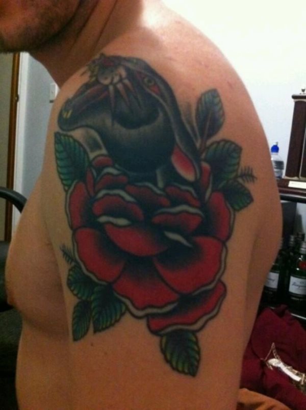 Este chico lleva la cabeza de una pantera que sale de una rosa tatuada sobre el brazo