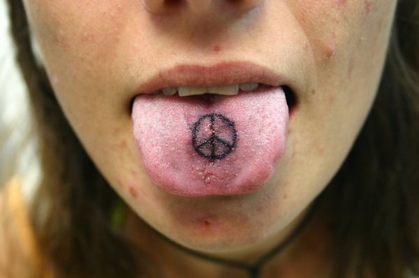 Tan simple como el símbolo de la paz y a la vez acertado para tatuar en la lengua, ya que la dificultad de que los dibujos se aprecien con claridad en la lengua, hace necesario escoger tatuajes sencillos para la lengua, en esta ocasión ha sido buena la elección de esta chica