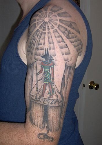 Tatuaje a color negro y en el que se ha dejado el color negro para dibujar y rellenar la piel del dios egipcio