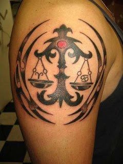 Una balanza y varios símbolos extraños componen este tatuaje con aires de tribal