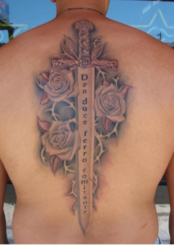 Espada tatuado a lo largo de la columna rodeada de rosas y con un mensaje en latn en el metal de la espada