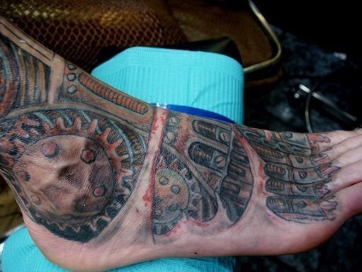 Tatuaje biomecánico que ocupa todo el empeine, tobillo y parte de la pierna, la verdad que nos gusta un montón como ha quedado sobre la piel de este hombre, que ha tenido un gran gusto al elegir su tatuaje y la suerte de encontrar a un buen tatuador, como lo son la inmensa mayoría y obtener este resultado digno de apreciar