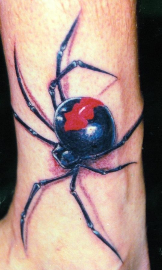 Tattoo de araña negra y roja con grandes y finas patas que recorren la piel de este joven, que quién sabe, lo mismo es amante de Spiderman y de ahí su afición por tatuarse una gran araña en la pierna, concretamente en el tobillo y que le da un aspecto exquisito a toda su pierna