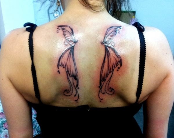 Tatuaje de alas de mariposa sobre la espalda de una mujer es un gran diseño para la gente que busca un tattoo elegante y con clase, en esta ocasión las líneas acabas en forma redonda y los puntos negros alrededor de las alas le dan un toque fantástico y digno de apreciar
