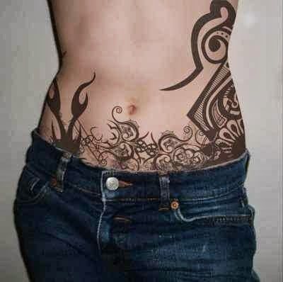 bonito tatuaje con motivos tribales en el abdomen de estachica, ocupando gran parte de la espalda