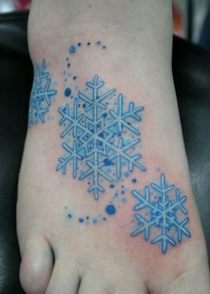 tres copos de nieve que dan hasta frío es el motivo del tatuaje que aquí nos atañe, copos que han sido completados con puntos azules de distinto tamaño que dan un bonito toque a este tatuaje, muy original e invernal y que no estábamos acostumbrados a ver, muy bueno