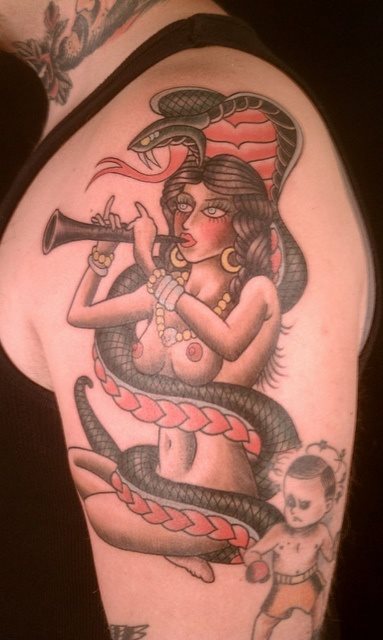 Una serpiente cobra rodea a una mujer desnuda que toca la flauta