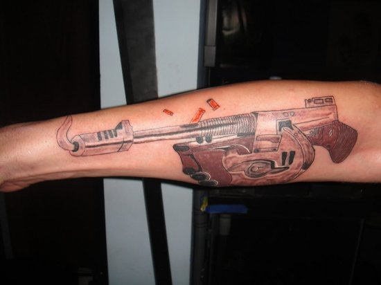 Si estabas acostumbrado a ver tatuajes de pistolas, aquí tienes un tatuaje de arma, pero diferente ya que no es la clásica pistola tatuada, sino una metralleta al estilo de la mafia italiana y del que se destaca la originalidad de tatuarla la metralleta en mitad de un tiroteo porque como podemos ver, sale humo del cañón y las balas van saliendo al ser disparadas