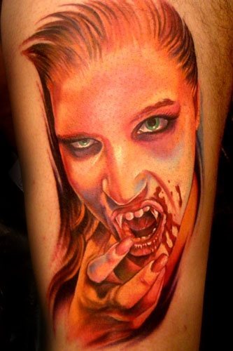 Tatuaje de una mujer vampira que se está tocando la boca ensangrentada y de grandes colmillos, con la mano a la que se lah ntatuado unas muy femenias uñas rojas