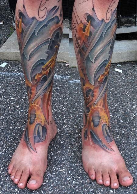 Tatuaje en las piernas que parecen carras de metal, envueltas en llamas naranjas, como podemos apreciar es un tattoo surrealista, para el que no se ha dejado ningún rastro de la piel sin tatuar