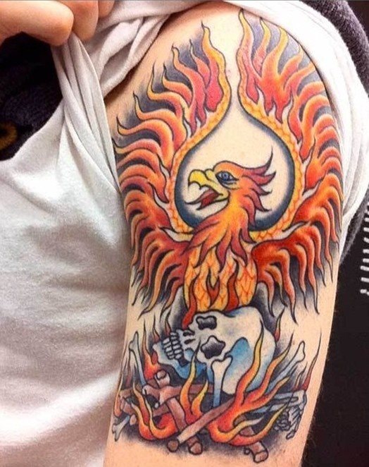 Ave fénix sobre una calavera en llamas han sido tatuadas sobre el hombro y brazo de este hombre