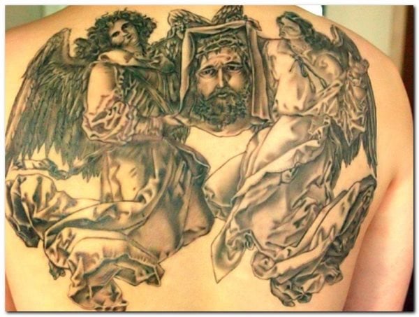 Tatuaje de Cristo custodiado por dos grandes ángeles alados con unas espectaculares túnicas de trazos y sombreados buenísimos, un maravilloso tatuaje que ocupa casi toda la espalda y para el que sólo se ha utilizado el color negro