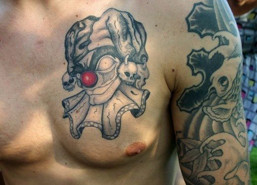 Tattoo de un payaso en el pecho en el que destaca la nariz roja