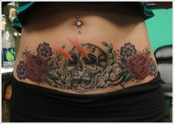 Calavera de color blanco con algo en los ojos y rodeado de dos rosas rojas a los lados