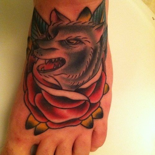 Tattoo de una rosa roja con la cabeza de un lobo encima