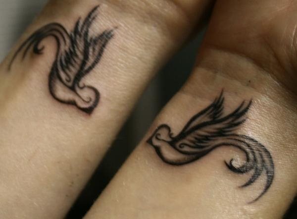 Dos pequeas golondrinas tatuadas en ambas muecas