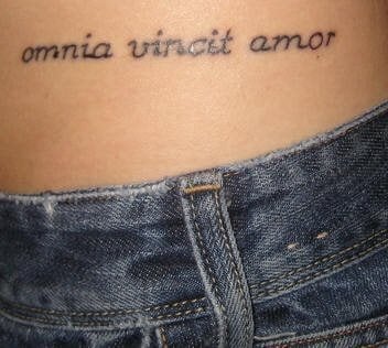 En esta ocasión nos encontramos ante un delicado tatuaje en la cintura con la frase Omnia vincit amor, para el que se ha utilizado una tipografía muy acertada gracias a tener unos trazos muy sencillos y sin decoración