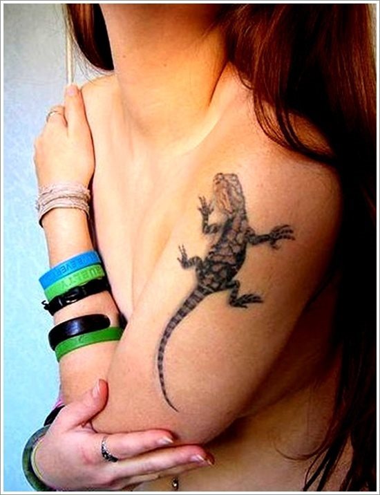Tatuaje de un lagarto en el brazo de esta chica, un tatauaje del que se ha conseguido dibujar una buena silueta, pero del que los trazos utilizados par realizar el relleno del lagarto tal vez no sean los que más nos gusten, ya que creemos que con un trazado más perfilados se hubiera conseguido un mejor resultado