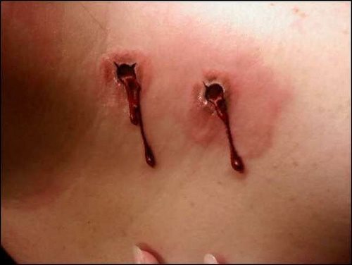 Original y realista tatuaje de las hendiduras de los dientes como si un vampiro le acabara de moder y le empeiza a salir un poco de sangre