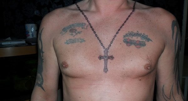 Este chico se ha tatuado el collar de una cruz que cae de su cuello como si fuera un colgante real