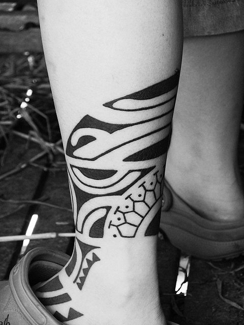 Tatuaje de tipo azteca en el gemelo y parte del pie, que ha sido realizado con líenas finas y trazos gruesos rellenados sólo a color negro, como es característico en este tipo de tatuajes, que en este caso en particuoar ha quedado muy bien