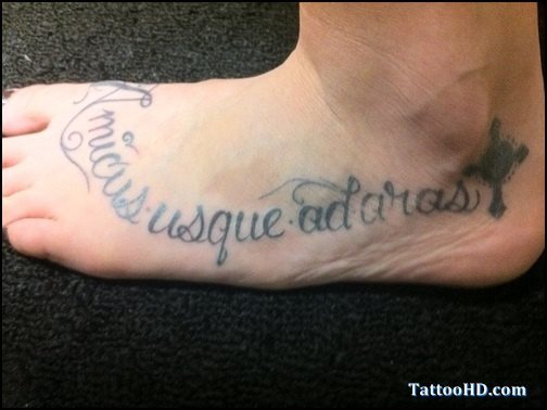 Tatuaje original en el pie, a pesar de que es difícil hallar la originalidad en tattoos en los pies, en esta ocasión se ha alcnazado gracias a la forma que va tomando la línea curva de las palabras y el acabado de una pequeña cruz bajo el tobillo