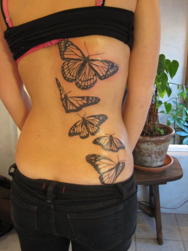 Tatuaje en la espalda de mariposas de gran tamaño que recorren desde la cintura, hasta llegar a la mitad de la espalda, el detalle de poner cada mariposa en un movimiento diferente del vuelo, le da un toque que hace de este tatuaje, un tattoo precioso