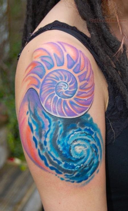 Precioso y colorido tatuaje que destaca en el brazo de esta chica con rastas, unos círculos en azul y morado que sombreados con el color naranja dejan caer unas llamas en forma de olas azules que impregnan una gran personalidad a esta chica y que hacen las delicidas de todos aquellos amantes de la piel tatuada 