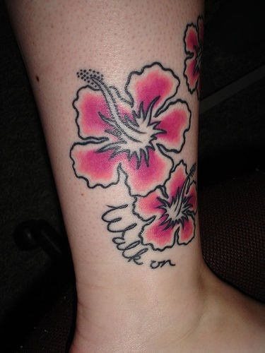 Tatuaje floral de estilo hawaiano y colores rosados sobre la pierna, un tatauje con pocos detalles, donde es en la sencillez donde estriba el gran resultado conseguido y la belleza impregnada en este tattoo
