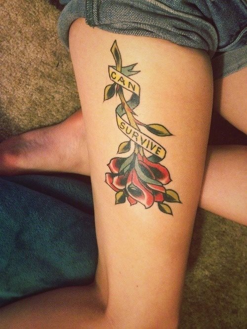Tatuaje en la pierna de una flor boca abajo a la que rodea un lazo que dice Can Survive, un tatuaje muy original por la forma en que se ha tatuado la flor, que tiene unos muy buenos sombreados