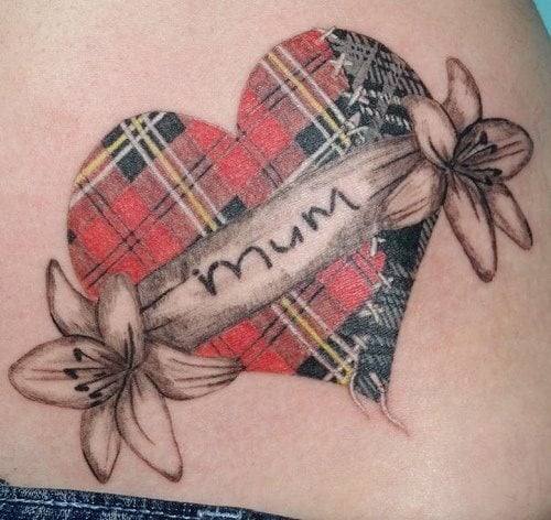 Tal vez un tatuaje de corazón es muy común, pero en esta ocasión se le ha querido dar un aspecto que lo hace diferente y éste es el tejido de tela escocesa con el que se ha coloreador más de la mitad del corazón y la otra mitad se ha dejado el mismo tejido pero en blanco y negro, acompañando a este original tatuaje de la palabra mamá en el centro de corazón gracias al trazo de las hojas de las flores