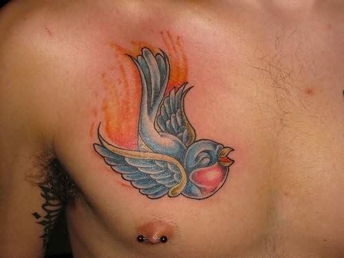 Tatuaje en el pecho de un pequeño y simpático pájaro con unas alas muy bonitas y unos colores muy adecuadso para este tipo de pájaro, los brillos y sombreados le dan un aspecto de gran calidad a este tatuaje