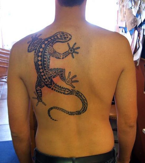 Gran tatuaje de un lagarto sobre la espalda con motivos aztecas, por nuestra parte es de los tattos de reptiles que más nos gustan, por muchos motivos: la zona, el tamaño y el buen trazado de los motivos aztecas para completar el tatuaje, un grandioso trabajo del tatuador y una magnífica elección de la persona que lo lleva sobre su piel