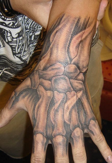Esqueleto de la mano tatuado sobre la parte anterior de la mano y el brazo