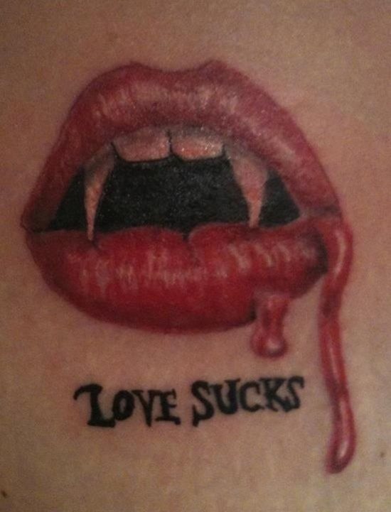 Tatuaje de los labios de una chica vampira con unos finos colmillos y restos de sangre que sobresalen por un lateral del labio