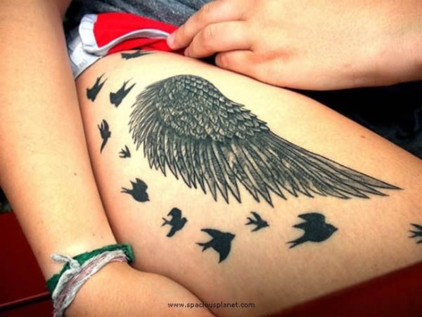 Tatuaje en la pierna de una ala de largas y finas plumas en tonos negros, que ha sido completado por un conjunto de pequeñas golondrinas negras que van rodeando al gran ala, sin duda un trabajo exquisto, para el que se ha escogido una muy buena zona